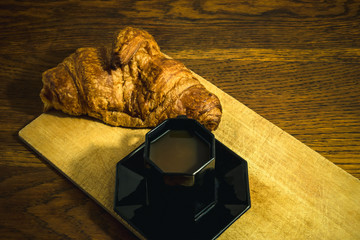Plan rapproché petit déjeuner au bistro avec une tasse de café noir expresso et un croissant au...