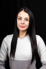 Portrait of serious beautiful female with black hair, has minimal makeup, looks calmly at camera,...