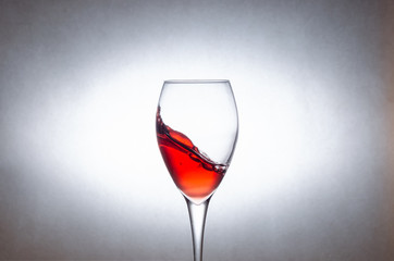 glass of red wine on a white background in motion. Freezing liquids in motion