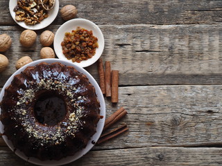 Festive homemade cakes. Round chocolate muffin, large biscuit or cake with chocolate icing on an ancient wooden background. Place for text, top view.