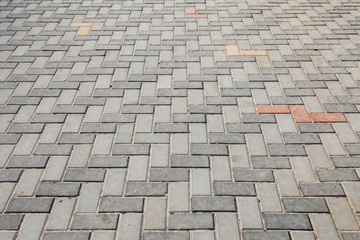 Gray cobblestone road pavement with colorful blocks