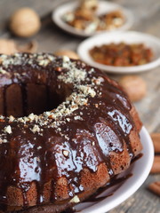 Festive homemade cakes. Round chocolate muffin, large biscuit or cake with chocolate icing on an ancient wooden background. Place for text, side view.