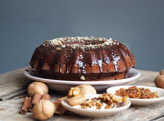 Festive homemade cakes. Round chocolate muffin, large biscuit or cake with chocolate icing on an ancient wooden background. Place for text, side view.