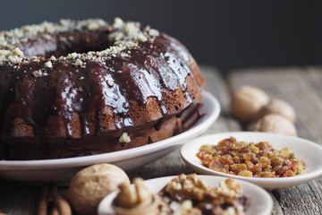 Festive homemade cakes. Round chocolate muffin, large biscuit or cake with chocolate icing on an ancient wooden background. Place for text, side view.