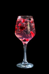 A single-colored, red cocktail in a tall glass with fine ice and lemon, lime and mint leaves, side view, isolated black background. Drink in a glass glass for the menu restaurant, bar, cafe