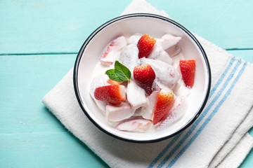 Strawberries and cream dessert on turquoise background