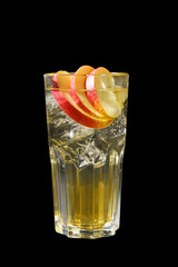 Transparent cocktail with syrup in a tall glass with ice cube, spices, cinnamon and slices of a red apple, Side view, Isolated black background, Drink for the menu restaurant, bar, cafe