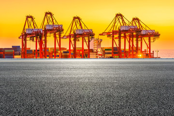Empty asphalt highway and industrial container terminal at beautiful sunset in Shanghai.