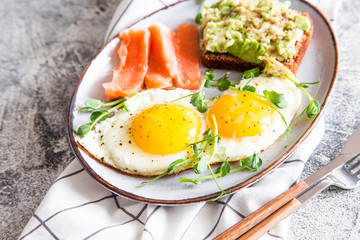 Egg breakfast. Healthy nutritious breakfast with eggs, salmon, avocado sandwich and sprouted pea seeds.