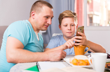 Man with his son are playing on phone together