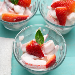 Strawberries and cream dessert on turquoise background