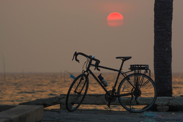 Fototapeta premium A bicycle with a sea backdrop at sunset