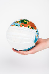 cropped view of woman holding globe in medical mask isolated on white
