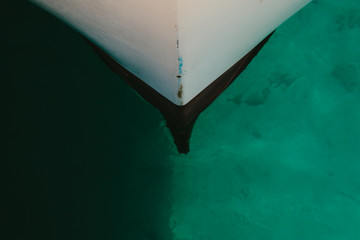 Punta de un barco dentro del agua transparente