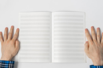 Obraz premium a view from above, person taking down the notes in notebook, empty blank paper mockup with copy space