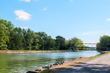 View of the Erie Canal and bridge at Holley, New York. Towpath walking and bicycling trail in the bright summer sun