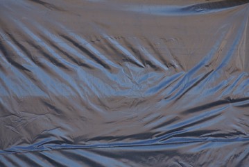 black plastic texture from a piece of old crumpled cellophane on the wall