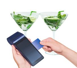 Two beautiful glasses with mojito and tubules.Payment by card purchase. Modern payment blue terminal and card. Isolated on white. Mint, rum, lime.