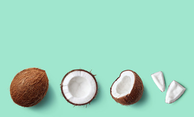 Row of fresh whole and half of coconut and slices