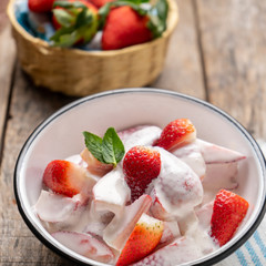 Strawberries and cream dessert on wooden background