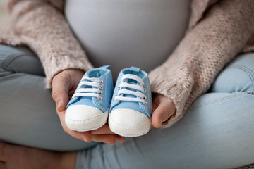 pregnant mother holding boy blu little shoes it´s a boy