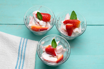 Strawberries and cream dessert on turquoise background