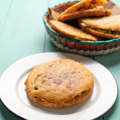 Mexican gorditas with pressed chicharron on turquoise background