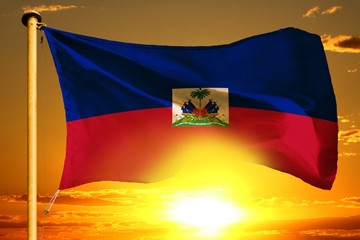 Fototapeta premium Haiti flag weaving on the beautiful orange sunset with clouds background