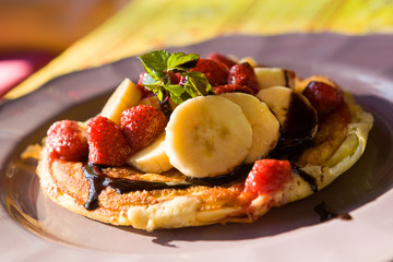 Homemade banana pancake with strawberry, banana and chocolate.