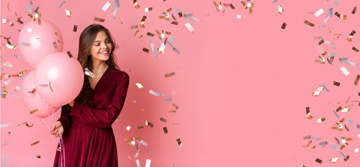 Joyful Girl Holding Balloons, Posing Over Pink Background With Flying Confetti