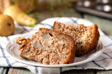Slice of homemade pie with pear and walnut on a plate, closeup, rustic style.