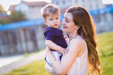 Mom holding her son, looking at him with love and affection. Mothers day