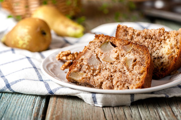 Slice of homemade pie with pear and walnut on a plate, closeup, rustic style.
