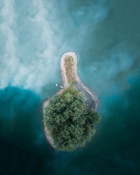 Magical island on a azure blue lake with boat on the shore
