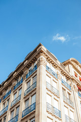 Beautiful traditional French traditional luxury apartment building with red awning sun protection and stone facade in haussmannian style - real estate property