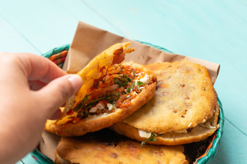 Mexican gorditas with pressed chicharron on turquoise background