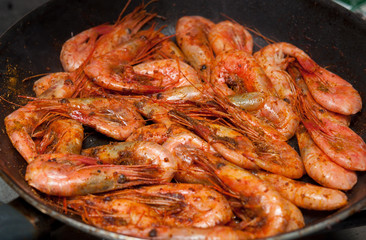 Prawns with spices are fried in a pan.