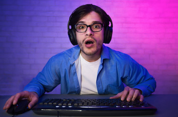 Amazed Guy Playing Computer Game Online Sitting At Home