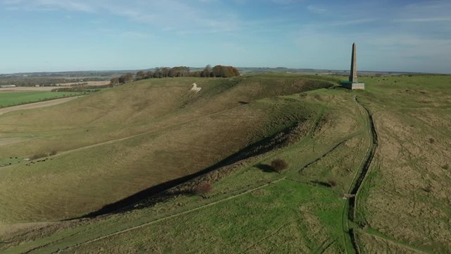 Aerial rising shot of Cherhill White Horse in the english countryside, shot in autumn with a bright blue sky.