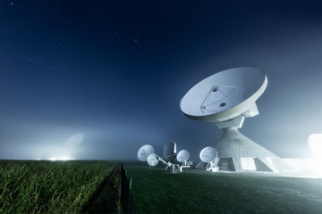 Satellite dishes at Raisting earth station in a foggy night