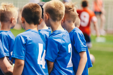 Fototapeta premium Kids Play Sports. Children Sports Team United Ready to Play Game. Children Team Sport. Youth Sports For Children. Boys in Sports Blue Uniforms. Young Boys in Soccer Jersey Sportswear