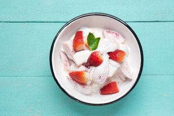 Strawberries and cream dessert on turquoise background