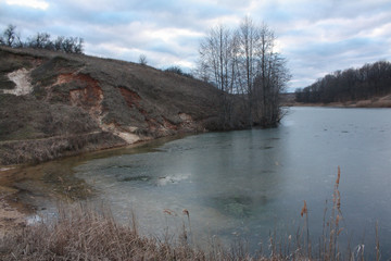 Winter landscape of a frozen lake surrounded by trees. Kharkov, Ukraine.