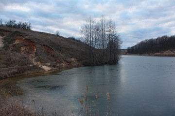 Fototapeta premium Winter landscape of a frozen lake surrounded by trees. Kharkov, Ukraine.