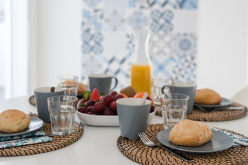 Plate with fresh crusty bread and glass of juice on grey plate