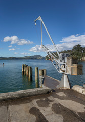 Naklejka na ściany i meble Whitianga coast New Zealand. Crane and pier. Jetty Coromendel