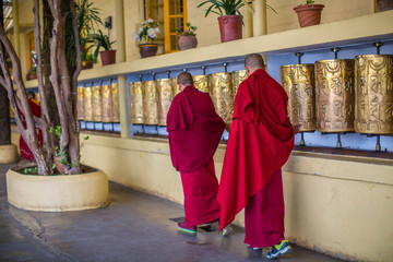 Monks spin the golden wheels. Buddhist prayer wheel Dharamshala India