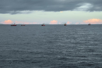 Barcos de pesca en el horizonte al atarceder