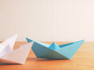 Naklejka premium Teamwork business concept with paper boat on a wooden table