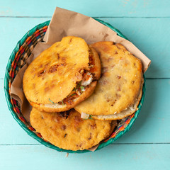 Mexican gorditas with pressed chicharron on turquoise background